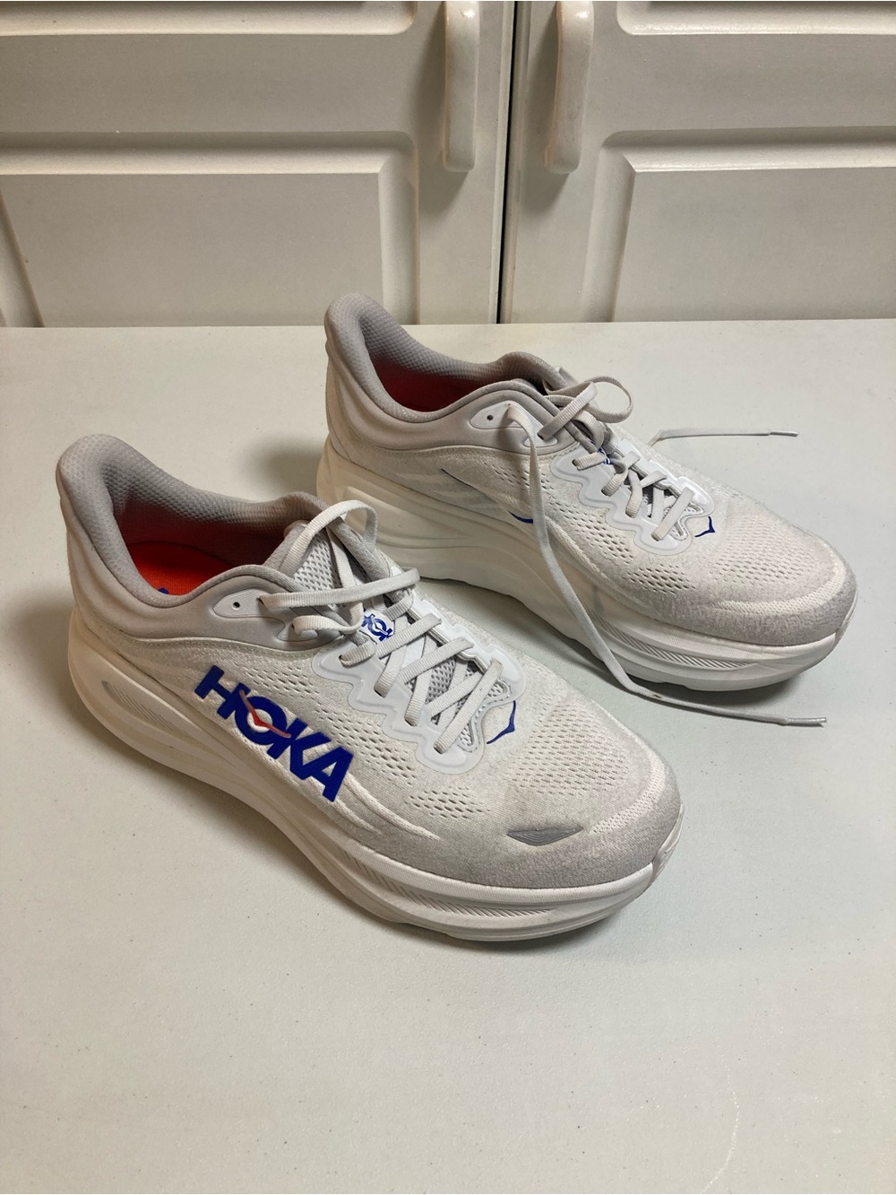 Hoka Men's White and Gray Running Shoes with Blue Logo and Red Inner Lining